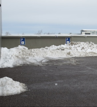 Parkplatz mit Behindertenparkplätzen, die aber mit Schnee zugemüllt sind